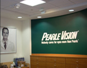 A green wall with the words " pearle vision ".