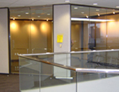 A glass wall in an office building with a railing.